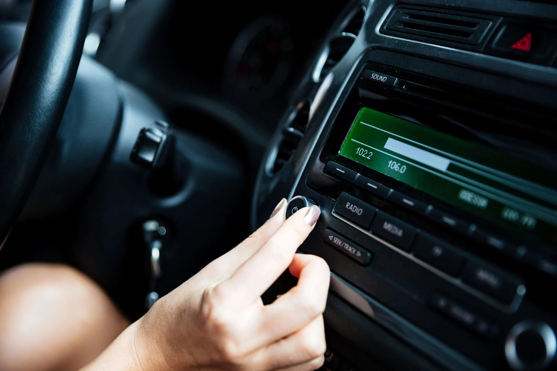 Female adjusting the radio of her car