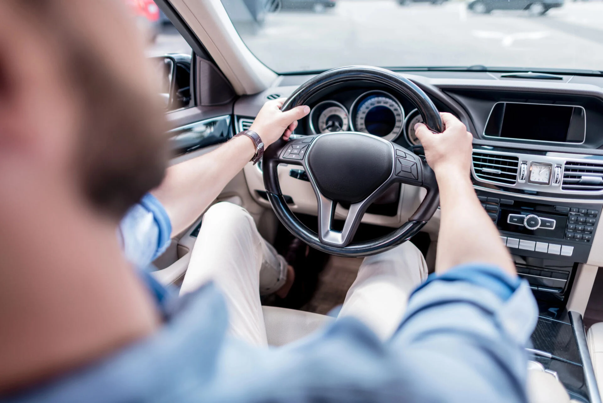 Person holding a steering wheel inside a car