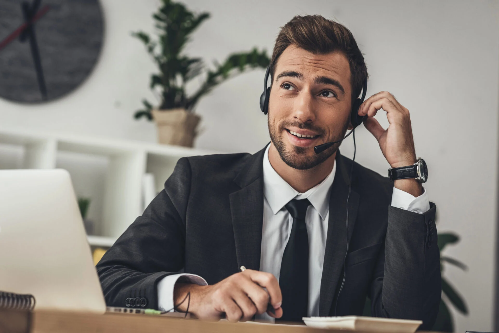 Man wearing a headset with laptop computer in front of him