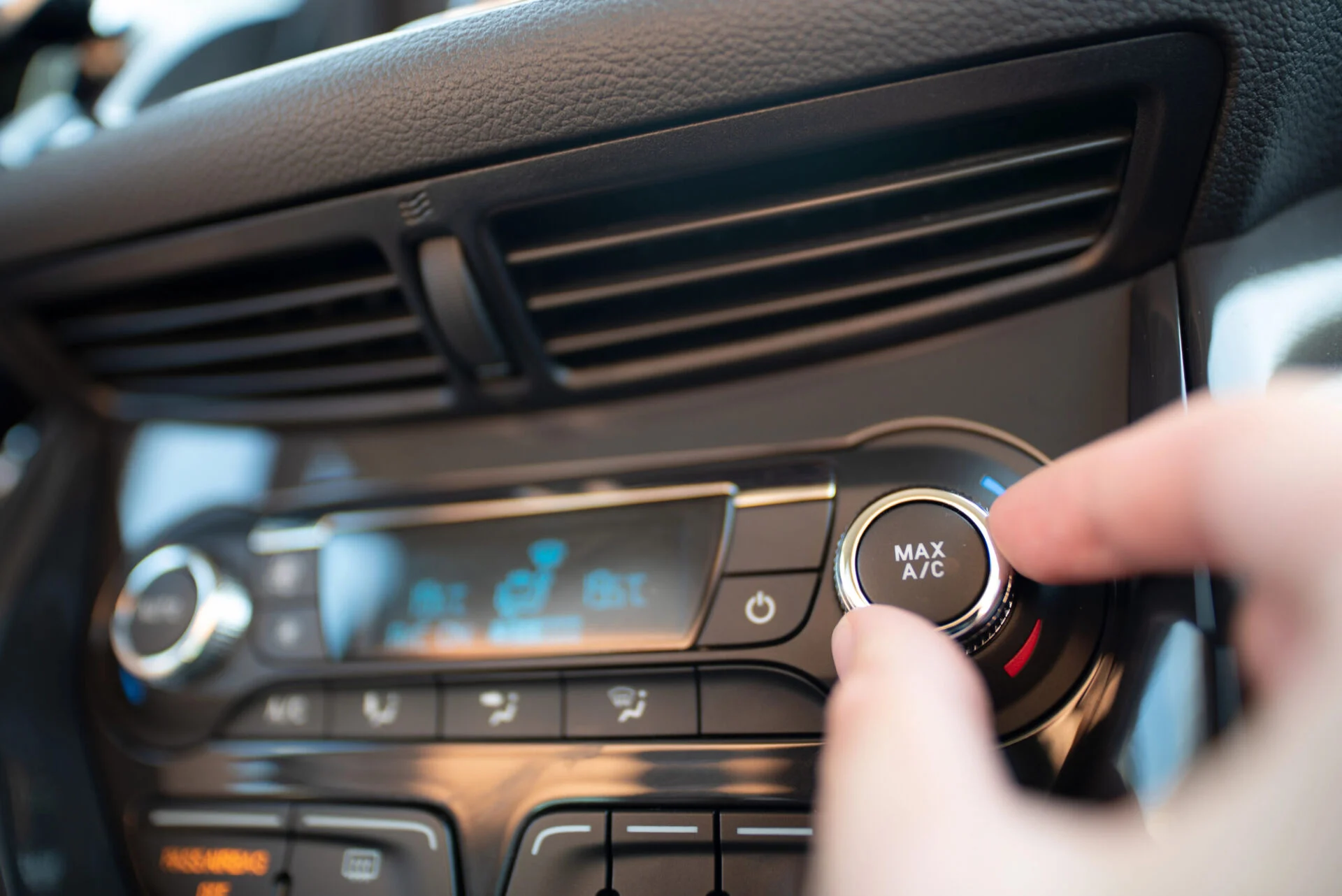 Close up of someone turning on car AC.