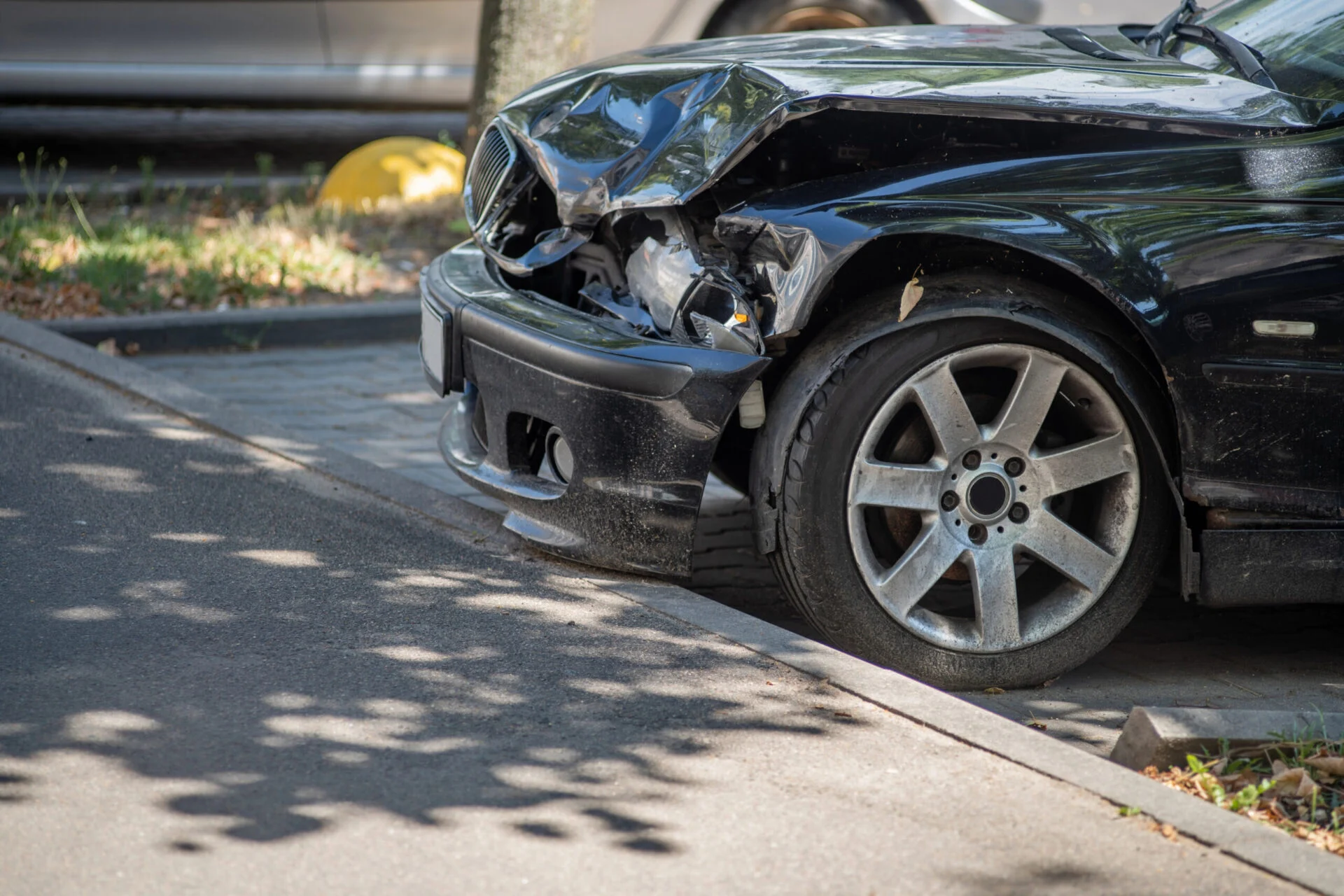 Smashed front end of a black car
