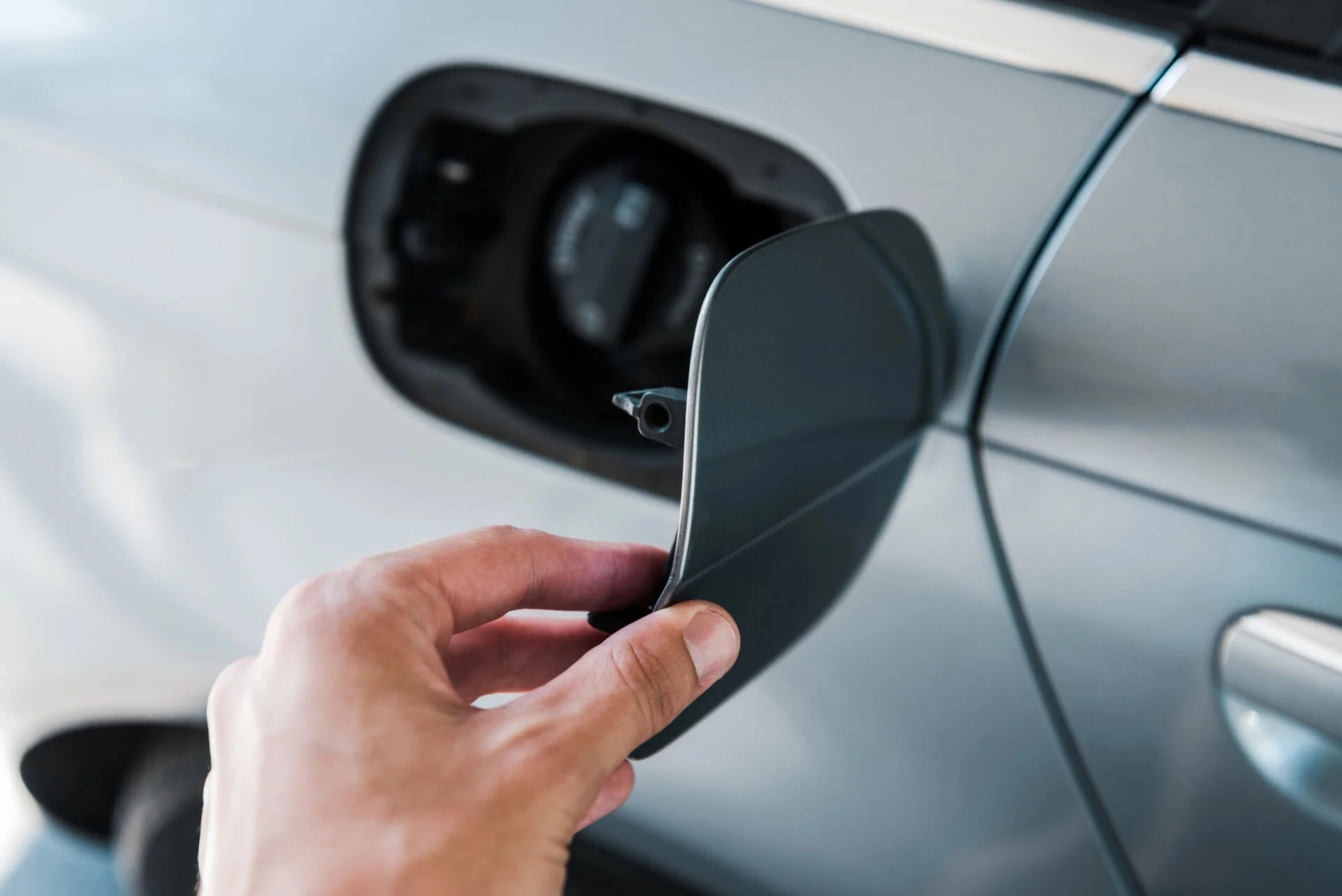 Close up of a person opening a gas tank on a car