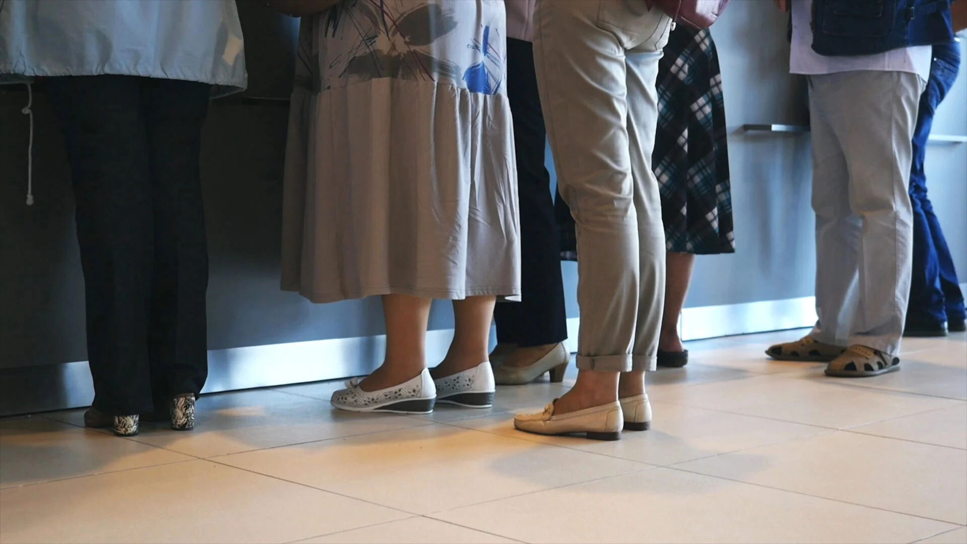 Close up of shoes of crowd waiting in line at DMV