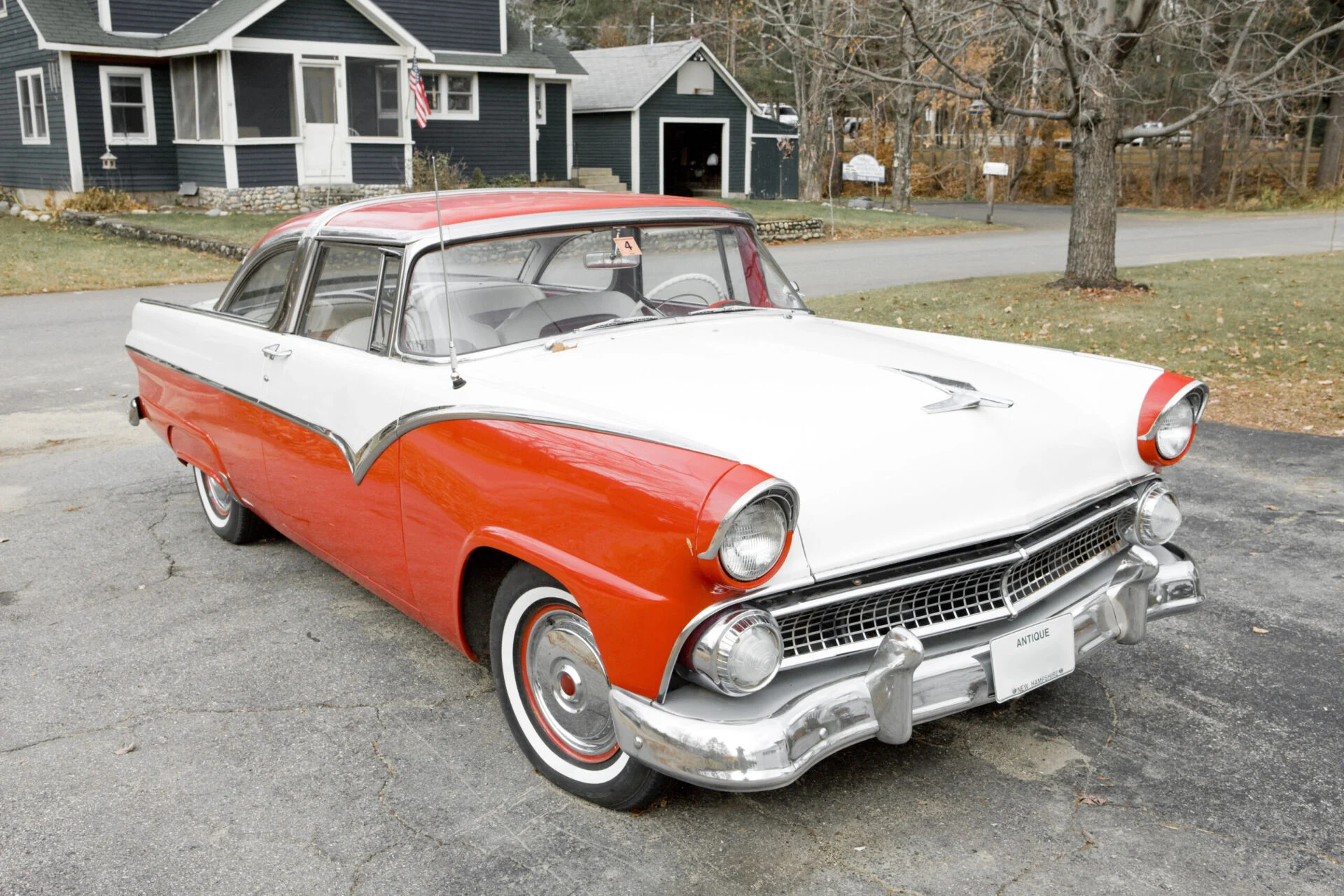 Classic antique car sits in the driveway of a home