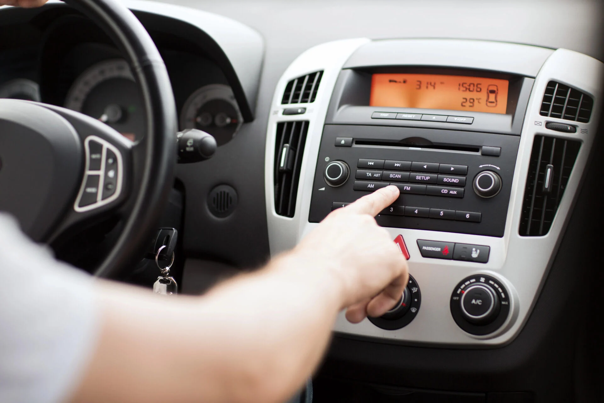 Driver adjusting car radio
