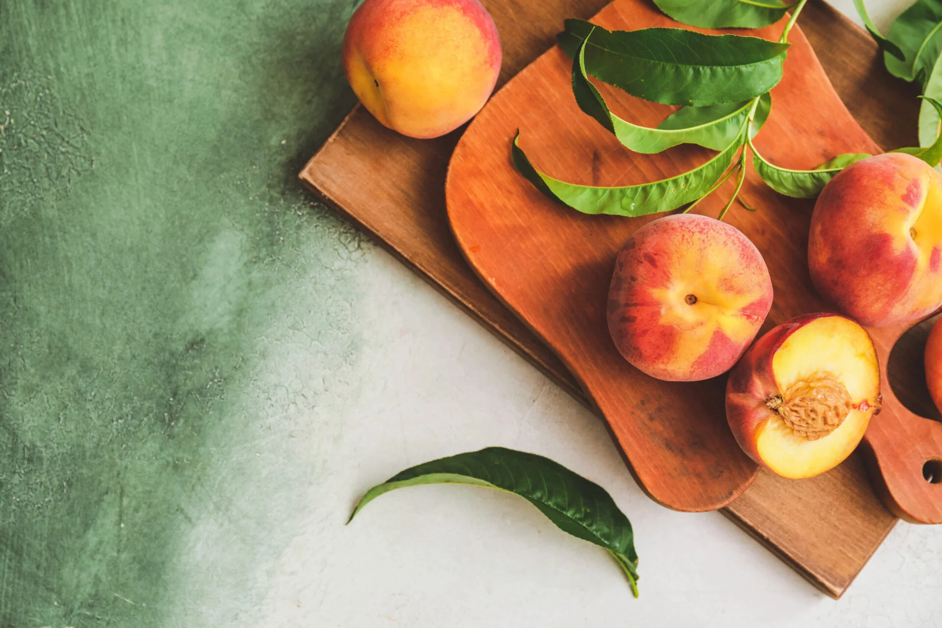 Boards with ripe peaches on color background