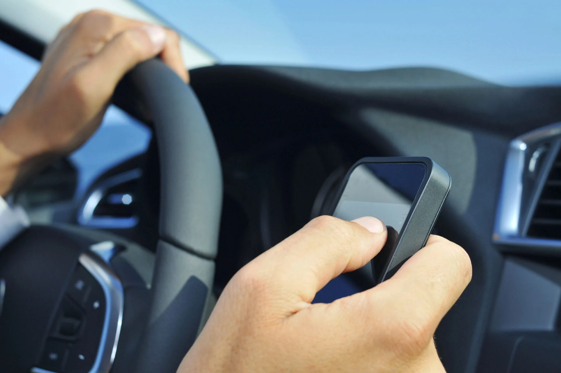 Closeup of a person using a cell phone while driving