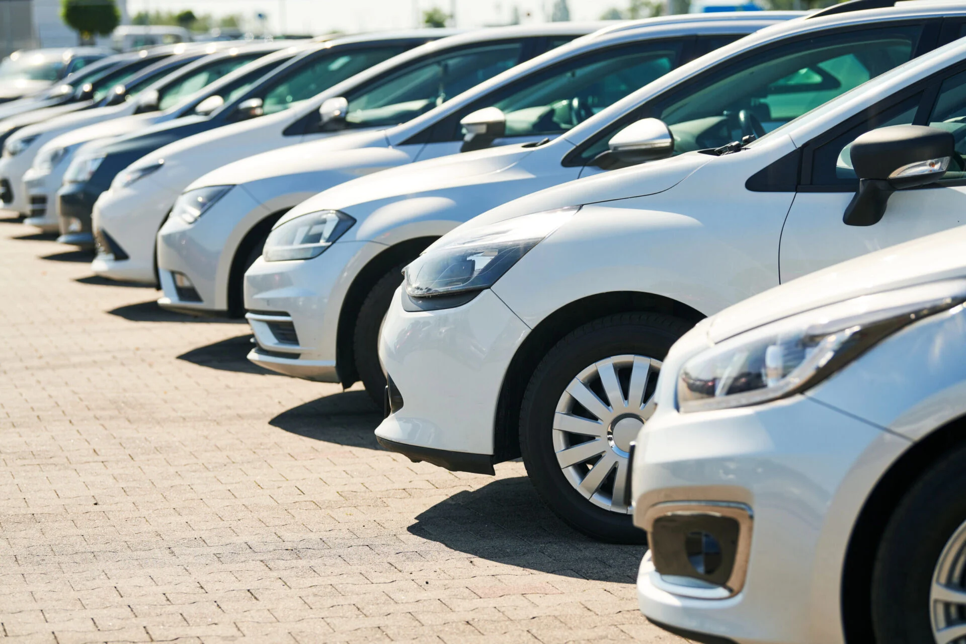 Row of cars in a dealership parking lot